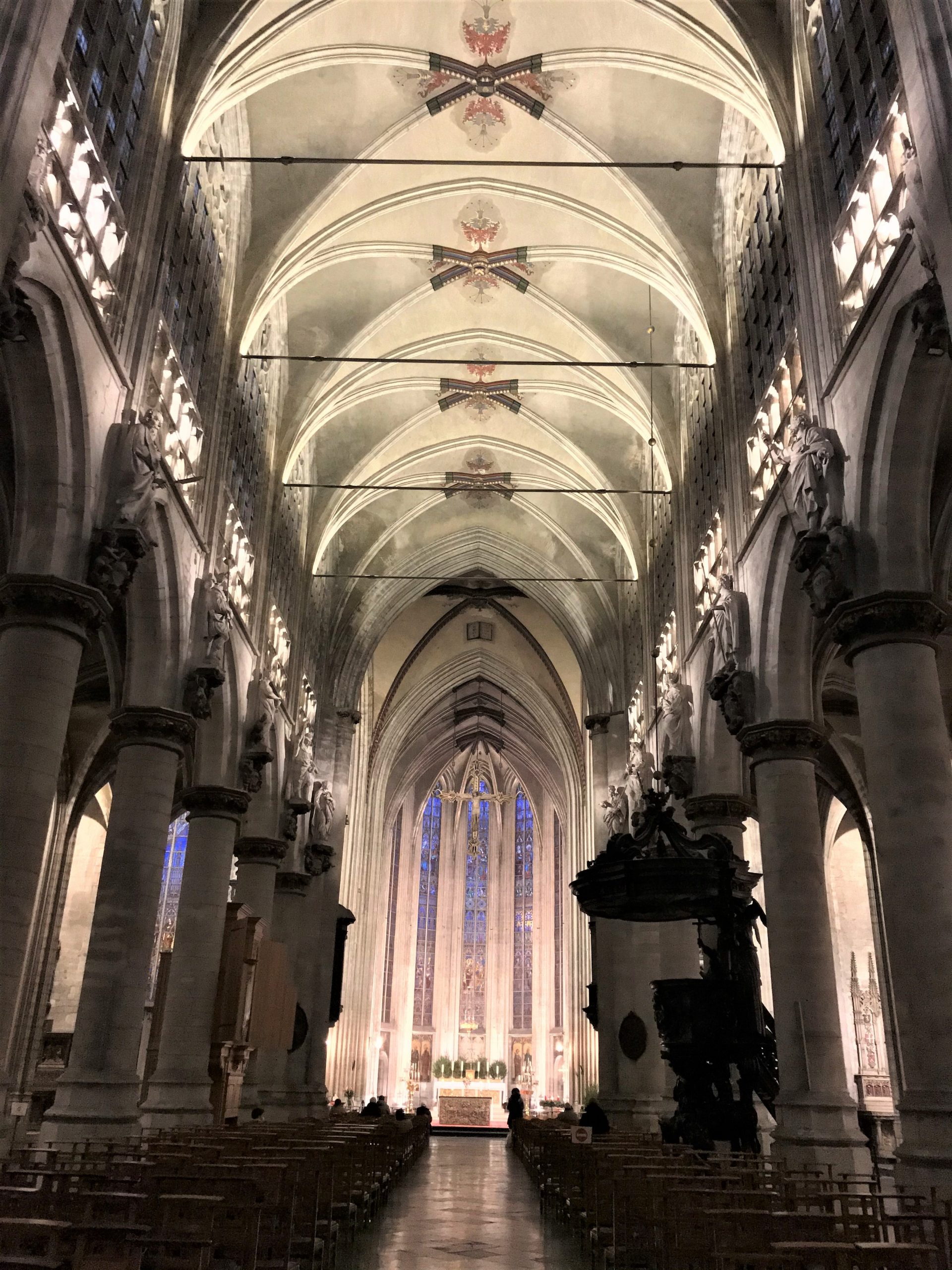 Zicht op het schip van de kerk en het koor met verlichting om de architectuur te benadrukken.