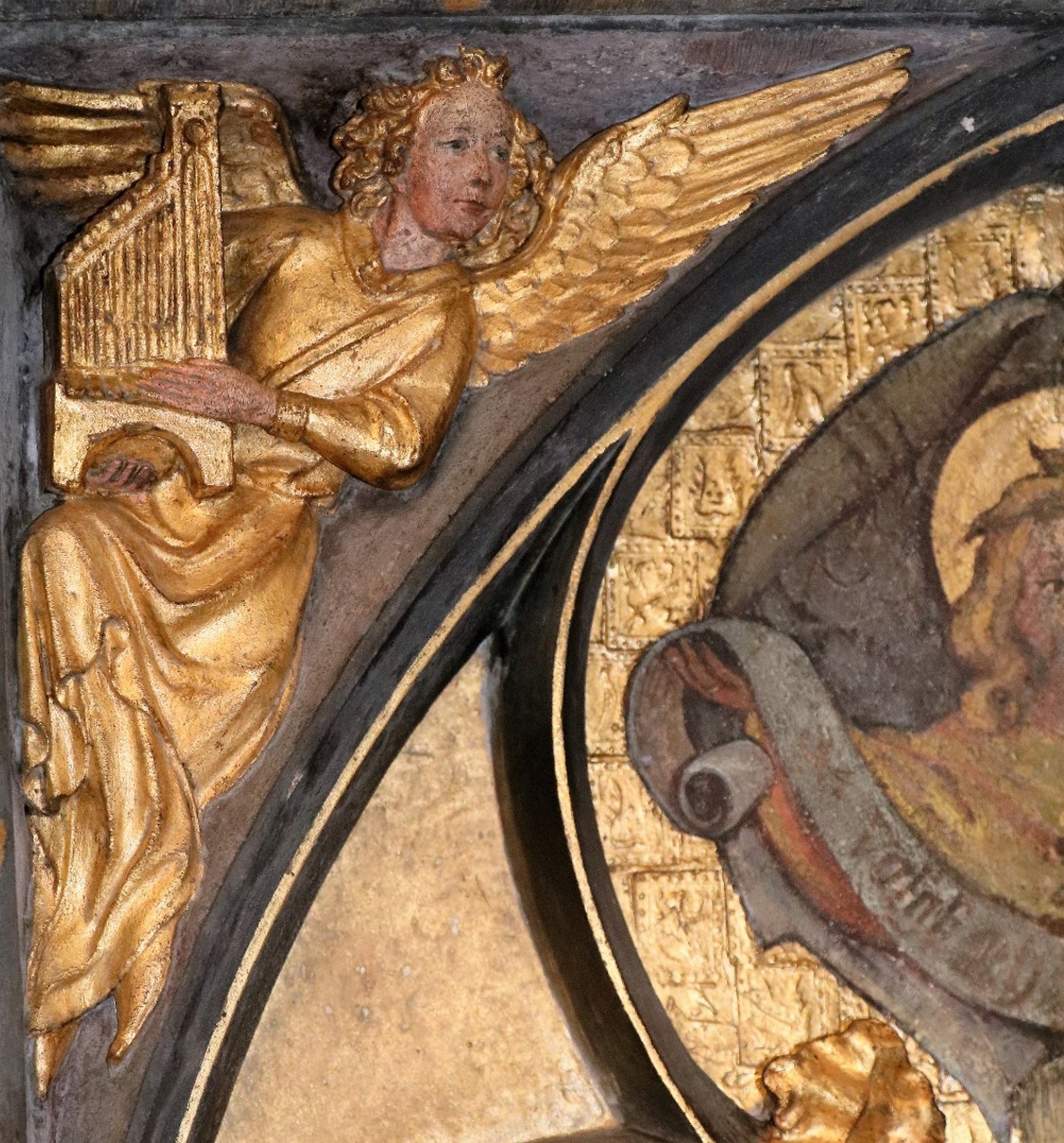 Detail van een engel die harp speelt, voorstellende een gerestaureerde borstwering. 