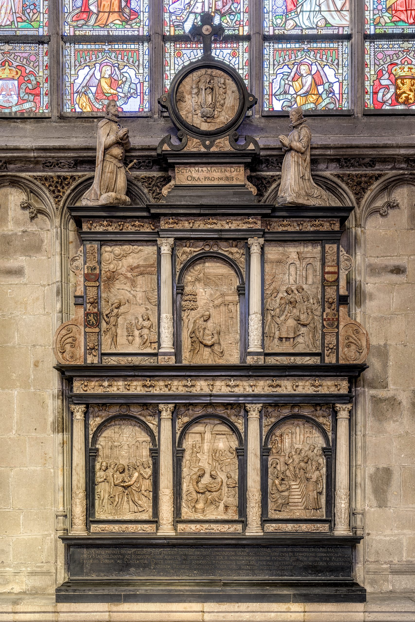 Gesneden stenen altaarstuk met verschillende religieuze scènes, omlijst door zuilen en bekroond door beelden, in de kerk Notre-Dame au Sablon.