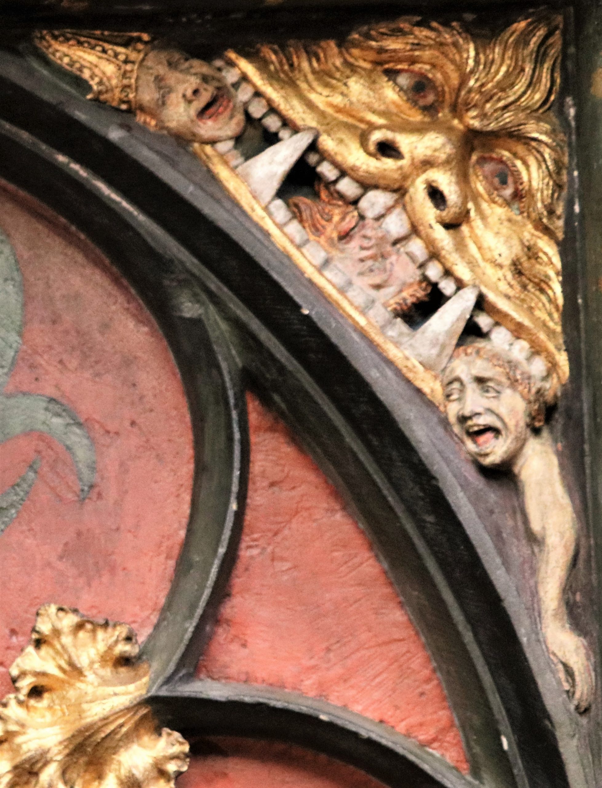 Detail van een beeld van een demon die een bisschop opslokt.