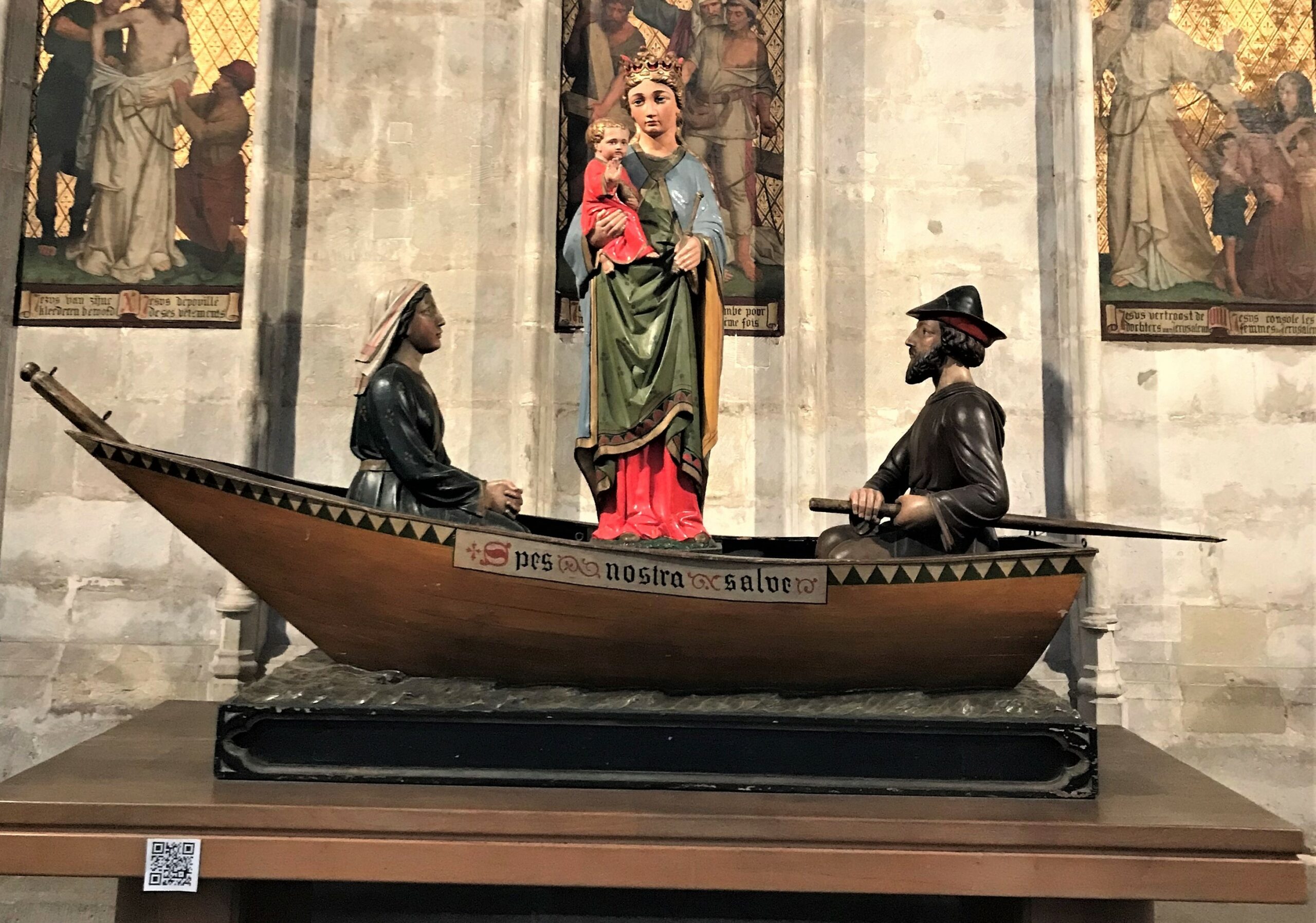 Installatie van een QR-code naast een kunstwerk in de kerk.